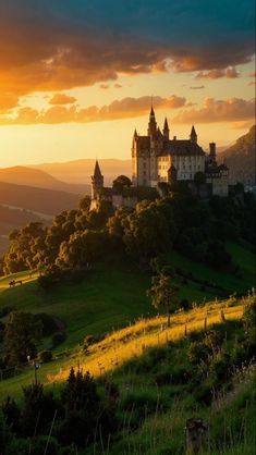 a castle sitting on top of a lush green hillside under a cloudy sky at sunset