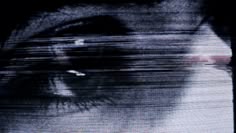 a blurry image of a person's face with their eyes wide open and looking at the camera