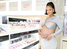 a pregnant woman is standing in front of cosmetics