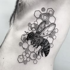 a man's chest with a bee and honeycombs tattoo on the side