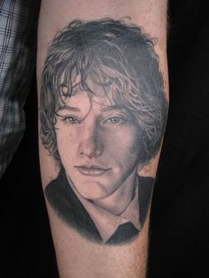 a man's arm with a portrait of him on it and his hair blowing in the wind