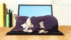 a paper cut out of a cat laying on top of a laptop