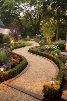 a garden with lots of plants and flowers in the center, surrounded by gravel path