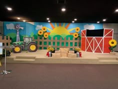 a stage set up with sunflowers and a farm scene painted on the wall