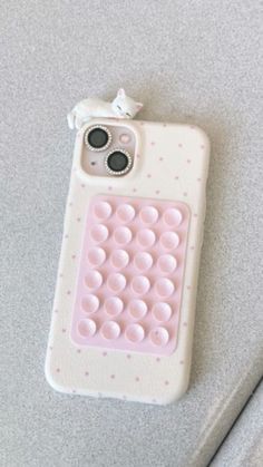 a cell phone case that is made out of white and pink material with polka dots on it