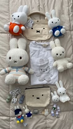 stuffed animals and clothing laid out on a bed
