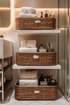 two wicker baskets sit on top of shelves in a bathroom