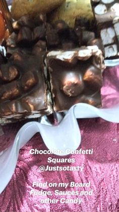 chocolate confecti squares and nuts sit on a pink tablecloth with white ribbon