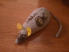 a stuffed animal mouse is sitting on the wooden floor with it's eyes closed
