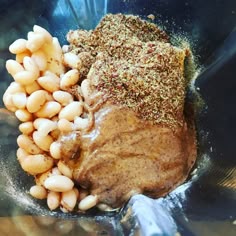 some beans and meat in a bowl with seasoning on top for garnish