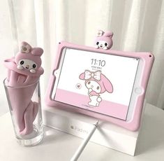 a pink tablet sitting on top of a table next to a vase filled with flowers