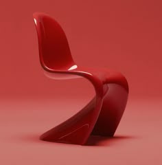 a red chair sitting on top of a pink floor next to a white object in front of a red wall