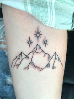 a tattoo with mountains and stars on it