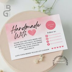 a close up of a piece of paper on a table with flowers in the background