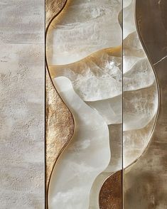 an abstract wall sculpture made out of glass and gold leafy shapes on the side