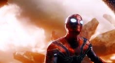 the spider - man is standing in front of an explosion