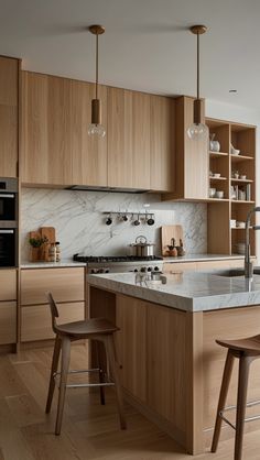 a modern kitchen with wooden cabinets and marble counter tops, two bar stools in front of the island