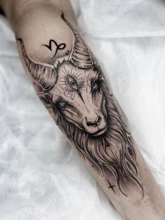 a black and white photo of a goat with horns on it's head tattoo