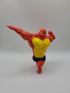a toy figure is posed on a white background with one arm raised and the other leg bent