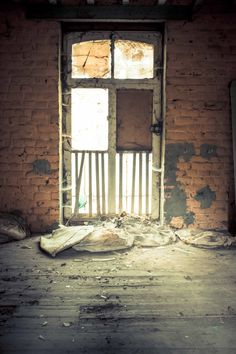 an old run down building with a broken window and debris on the floor in front of it