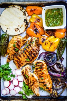 grilled chicken fajitas on a tray with peppers and onions
