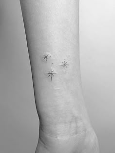 a woman's foot with three small stars on her left side tattooing it