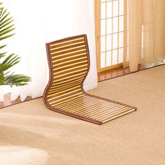 a wooden chair sitting on top of a carpeted floor next to a potted plant