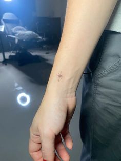 a person with a small star tattoo on their wrist
