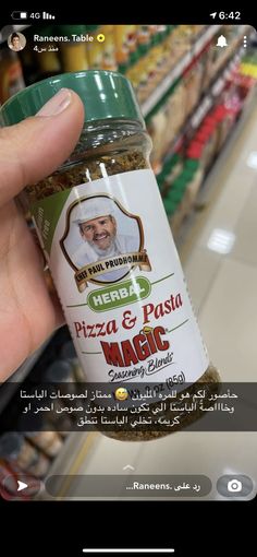 a person holding up a jar of pizza and pasta magic in front of a grocery store