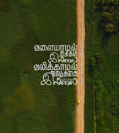 an aerial view of a dirt road in the middle of a green field with words written on it