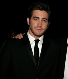 two men in suits posing for the camera