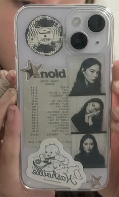 a person holding up a cell phone case with stickers on the back of it