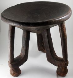 an old wooden stool sitting on top of a white floor