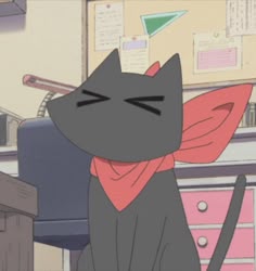 a black cat sitting on top of a desk