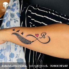 a woman with a tattoo on her arm that has an arrow and heart in it
