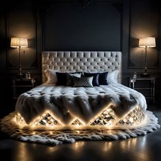 a large bed with lights on it in a dark room next to two lamps and a chandelier