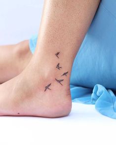 a woman's foot with three small birds on the top and bottom of it