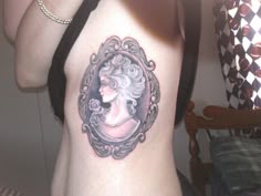 a woman's back with a frame tattoo on her left side ribcage