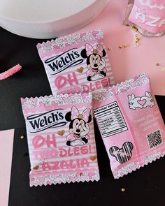 three candy bags with minnie mouse on them sitting next to a bowl and spoons