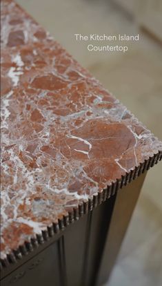 the kitchen island countertop is brown and white marble with silver veining on it