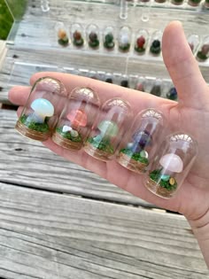a person holds out their hand with several small glass objects in the shape of animals