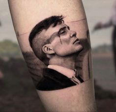 a black and white photo of a man's face on the arm