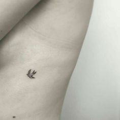 a small tattoo on the back of a woman's stomach