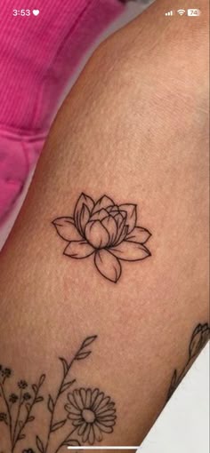 a woman's arm with a flower tattoo on it