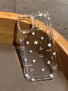 an iphone case with flowers and hearts on it sitting on top of a wooden chair