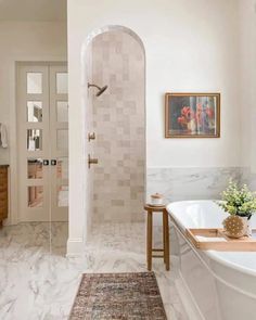a bathroom with a bathtub, sink and rug on the floor in front of it