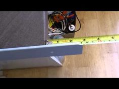 there is a measuring tape on the floor next to a box with wires in it