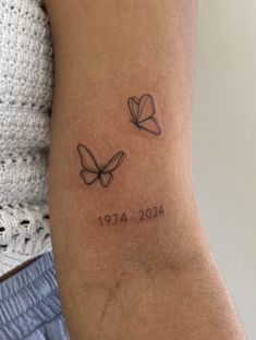 a woman's arm with two butterflies and the date 1911 - 2014 on it