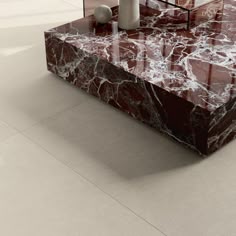 a marbled coffee table with two vases on the top and one in the middle