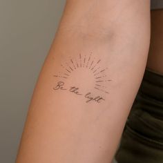 a woman's arm with a tattoo that reads be the light on it,